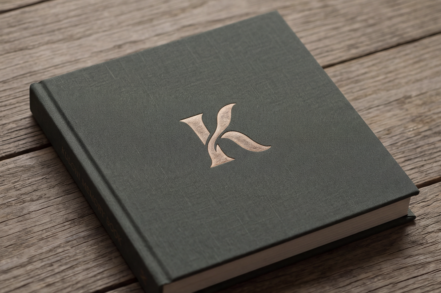 A dark sage cloth-bound Kulohi book on a wooden table